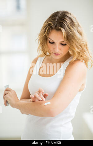 Woman applying pomade on her elbow. Stock Photo