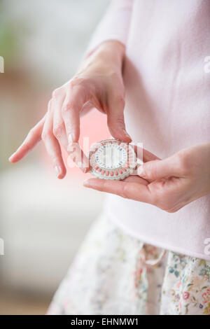 Woman taking an hormone replacement therapy pills. Stock Photo