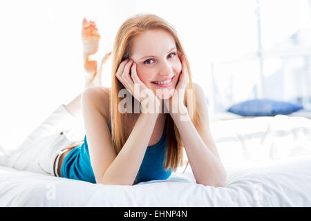 Young woman lying in bed. Stock Photo