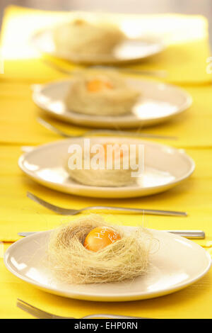 Easter table with plates decorated with nest and eggs Stock Photo
