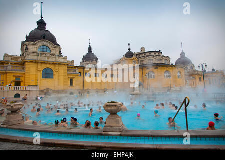 Tourists and locals enjoy the Széchenyi Thermal baths on a cold winter's day, Budapest, Hungary Stock Photo