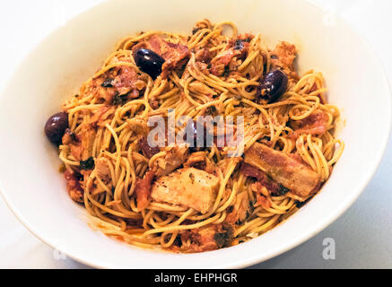 Spaghetti with tuna, bacon, olives, and tomato sauce in a white bowl Stock Photo