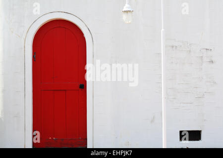 Old wooden red door with white wall Stock Photo