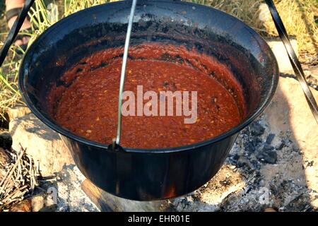 Chili con carne in a pot over a campfire Stock Photo