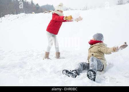 Two children having snowball fight Stock Photo