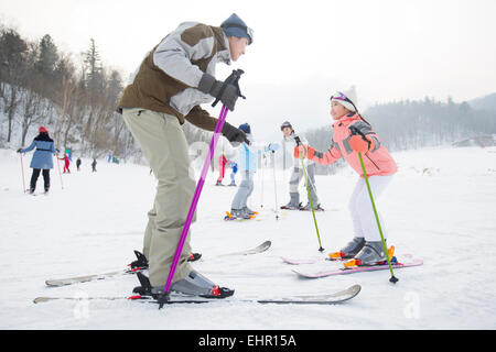 Young parents teaching children to ski Stock Photo