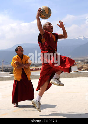 (150317) -- SHANGRI-LA, March 17, 2015 (Xinhua) -- File photo taken on March 15, 2010 shows monks playing basketball at the Yunnan Institute of Buddhist Studies Diqing Branch in Shangri-la County, southwest China's Yunnan Province. Located at an altitude of 3,300 meters, Yunnan Institute of Buddhist Studies Diqing Branch is an important school of Tibetan Buddhism in Yunnan. Established in 2005, the institute now has a total of 68 monks, who are from some monasteries in Yunnan, Sichuan and Tibet. Besides daily chanting sutras, monks here also take classes such as Tibetan language, Chinese, Budd Stock Photo