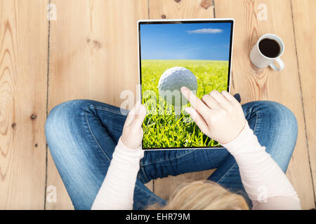 woman pointing on golf ball on tablet Stock Photo