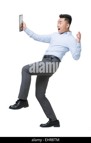 Young businessman holding digital tablet with surprised expression Stock Photo