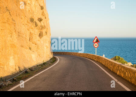 Narrow coastal road winding high up along cliffs Stock Photo