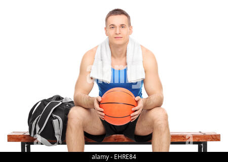 Young male basketball player sitting on a bench isolated on white background Stock Photo