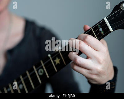 Closeup of a womans hands playing a banjo Stock Photo