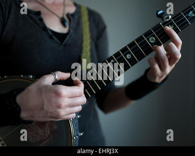 Closeup of a womans hands playing a banjo Stock Photo