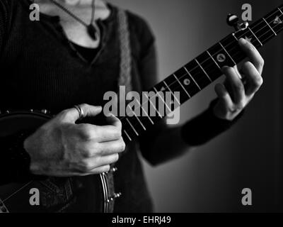 Closeup of a womans hands playing a banjo Stock Photo