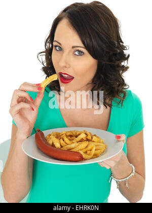 Confident Happy Young Woman Eating Authentic Chip Shop Takeaway Saveloy Sausage And Chips Isolated Against A White Background With A Clipping Path Stock Photo