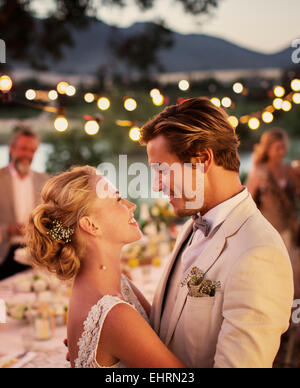 Portrait of young couple dancing in garden during wedding reception Stock Photo