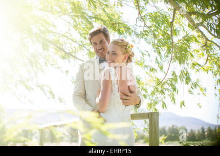 Portrait of young couple embracing on wooden bridge Stock Photo
