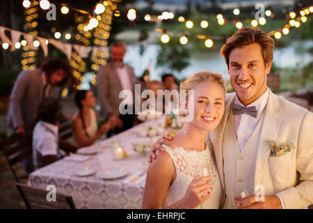 Portrait of young couple during wedding reception in domestic garden Stock Photo