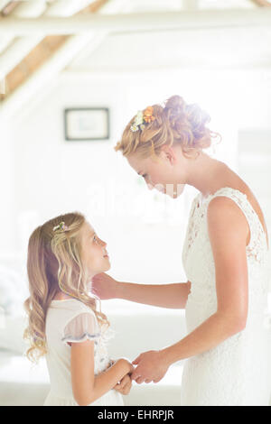 Bride talking to bridesmaid in domestic room Stock Photo