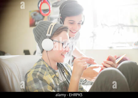 Two teenage boys listening to music on headphones Stock Photo