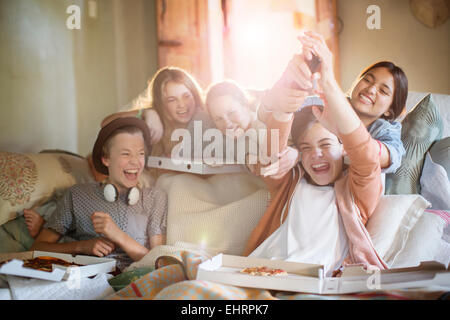 Group of teenagers having fun while watching tv on sofa Stock Photo