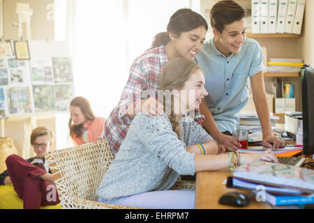 Teenagers sharing computer in living room Stock Photo