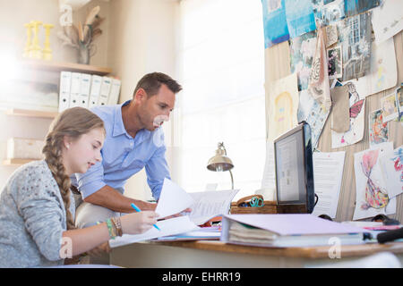 Father helping teenage daughter with her homework Stock Photo