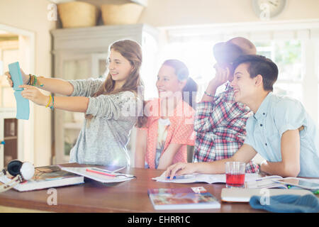 Group of teenagers taking selfie in dining room Stock Photo