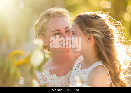 Bride talking to Bridesmaid in domestic garden Stock Photo