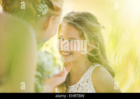 Bride talking to Bridesmaid in domestic garden Stock Photo