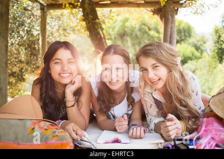 Three teenage girls having fun in tree house in summer Stock Photo