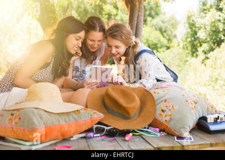 Three teenage girls using digital tablet in tree house Stock Photo