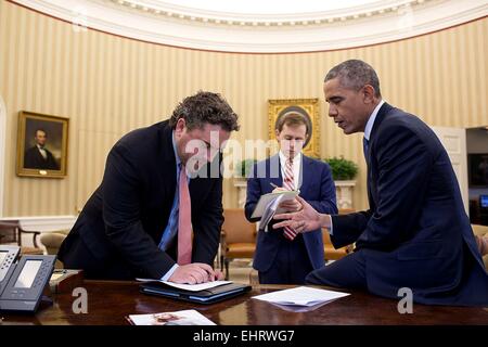 US President Barack Obama works on his immigration speech with Director of Speechwriting Cody Keenan and Senior Presidential Speechwriter David Litt in the Oval Office of the White House November 19, 2014 in Washington, DC. Stock Photo