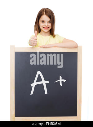 smiling girl with blackboard showing thumbs up Stock Photo
