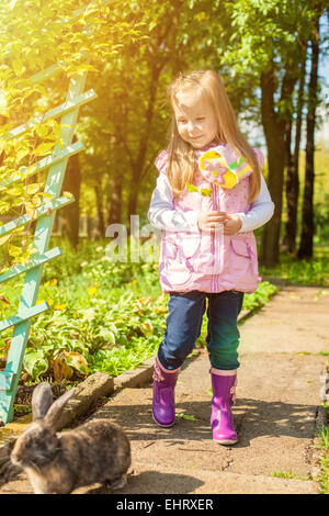 Pretty little girl walking with cute rabbit Stock Photo