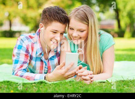 smiling couple with smartphone and earphones Stock Photo