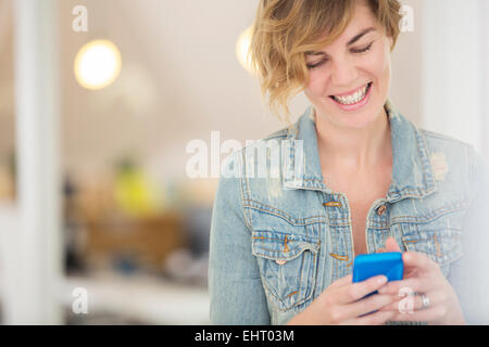Smiling office worker using smart phone Stock Photo