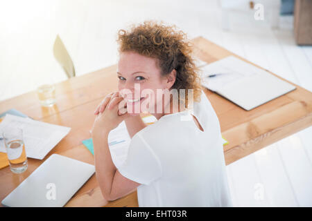 Portrait of young smiling office worker at desk Stock Photo