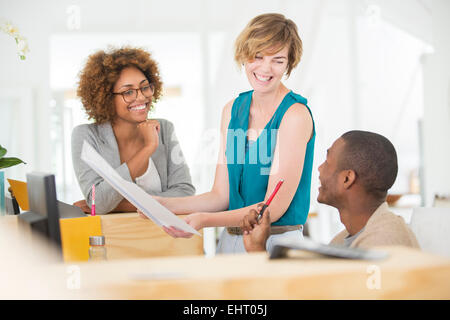 Colleagues talking and smiling in office,holding documents Stock Photo