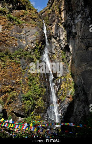BHUTAN - Prayer flags by a waterfall near the entrance to Taktshang Goemba, (the Tiger's Nest Monastery. Stock Photo