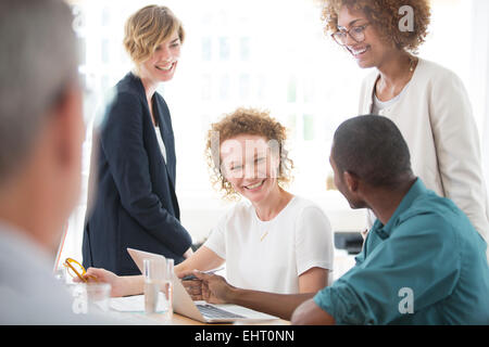 Group of office workers talking at desk Stock Photo