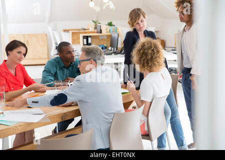 Group of office workers talking at desk Stock Photo