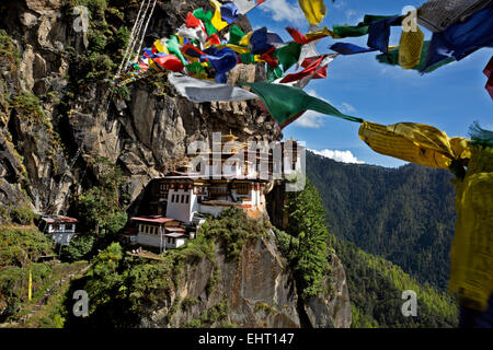 BHUTAN - Prayer flags strung on hills around Taktshang Goemba, (Tiger's Nest Monastery), perched on the side of a cliff. Stock Photo