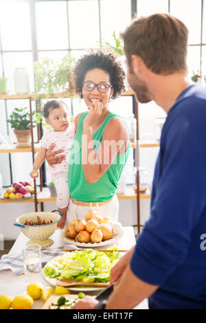 Happy family preparing meal in domestic kitchen Stock Photo