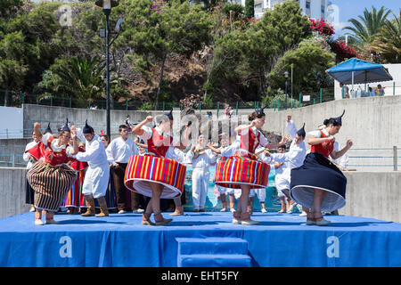 Dancers with local costumes demonstrating a folk dance at the beach of Funchal, Madeira Island, Portugal Stock Photo