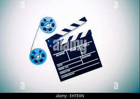 Two vintage 8mm blue reels connected with film and clapper board vintage color style Stock Photo