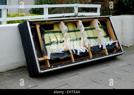 old piece of furniture discarded on a pavement Stock Photo