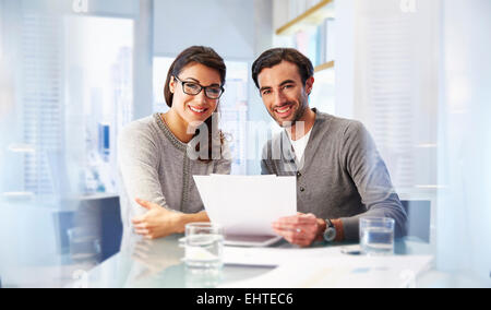 Portrait of man and woman working together in office Stock Photo