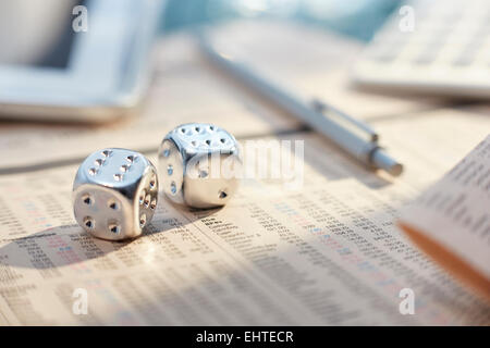 Close up of silver dice with sixes on messy desk Stock Photo