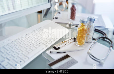 Flasks with pills,stethoscope and keycard,View of desk with computer Stock Photo